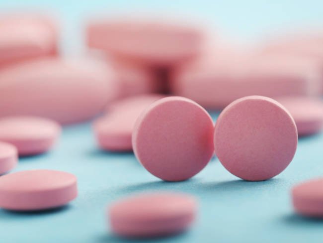 Pinke Tabletten vor blauem Hintergrund