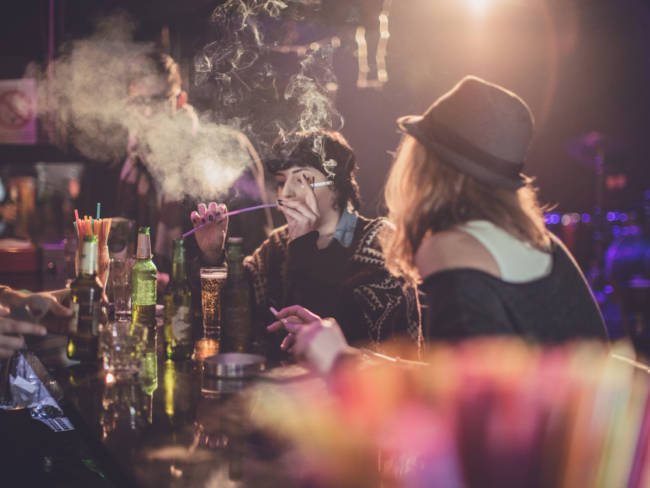 Gruppe von Freunden rauchen in Bar